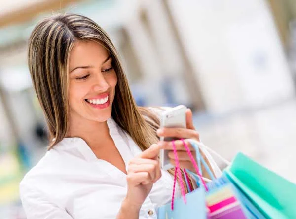 Happy Woman Using Cell Phone at a Shopping Center